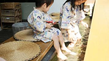 Guests can sit and relax by the serene water feature, surrounded by wicker furniture and a woven mat.
