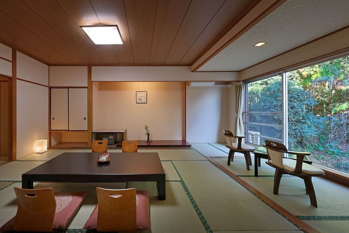 A traditional Japanese room with tatami flooring, a low table, and sliding doors.