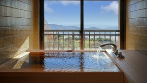 Une salle de bain avec une grande fenêtre, une baignoire et un robinet.