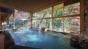 Un bain à remous avec vue sur le paysage automnal, grâce à de grandes fenêtres.