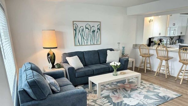 A modern living room with a sofa, coffee table, and floral rug. - Waterfront Getaway with Boat Slip (Ocean City)