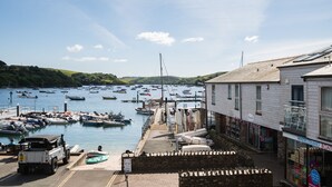 A harbor with boats, a white building with a sign 'White Strand Boat', and a parked vehicle.