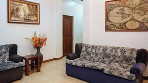 A room with two sofas, a wooden door, and a large map on the wall. - C Star Travellers Inn (Oslob)