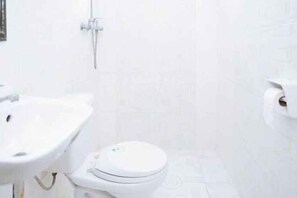 A bathroom with a white sink, toilet, and shower. - C Star Travellers Inn (Oslob)