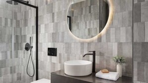 A modern bathroom with a glass shower enclosure, a white toilet, a round sink with a black faucet, and a large mirror with a gold frame. - Premium apartment Ca' San Marco in a historic town (Labin)