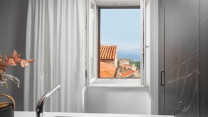 A modern bathroom with a window, a sink, and a view of buildings. - Premium apartment Ca' San Marco in a historic town (Labin)