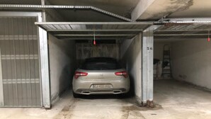 Ein Auto steht in einer Garage mit Betonboden und Metallwänden.