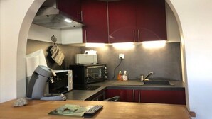 Eine kleine Küche mit Mikrowelle, Toaster und Spüle.