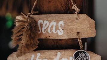 A wooden sign with the text "seas the day" and a small tag that says "THANK YOU SURFING".