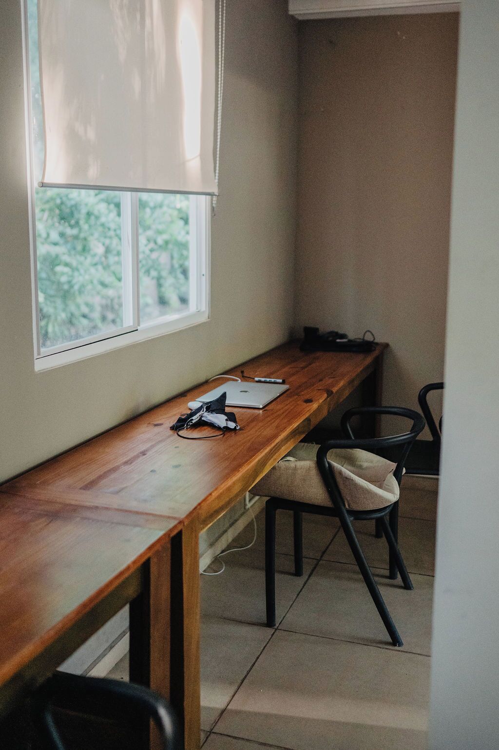 A room with a wooden desk, a laptop, and a chair.
