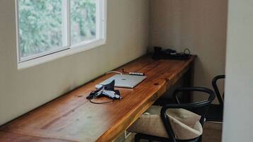 A room with a wooden desk, a laptop, and a chair.
