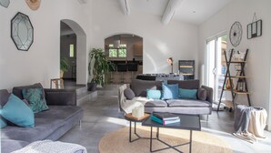 A spacious living room with two sofas, a coffee table, and a bookshelf. - Maison Loutina, Villa 5-10 min à Pied du Centre (L'Isle-sur-la-Sorgue)