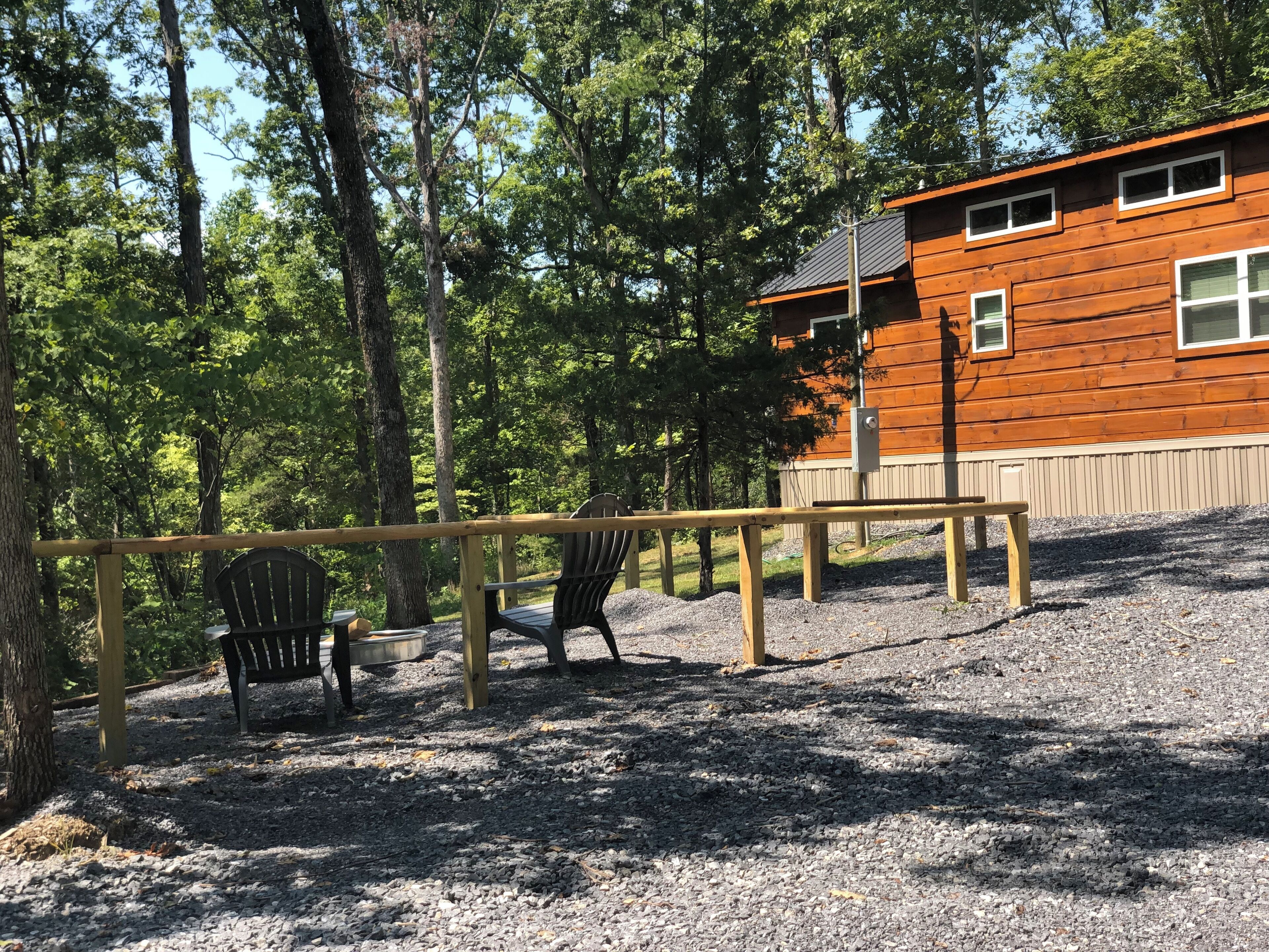 Eine Holzhütte mit Kiesgrund, umgeben von Bäumen.