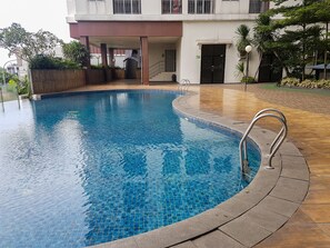 Relax by the pool surrounded by lush greenery and a tranquil atmosphere.
