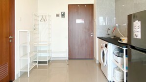 Una cocina moderna con lavadora, refrigerador y puerta de madera.