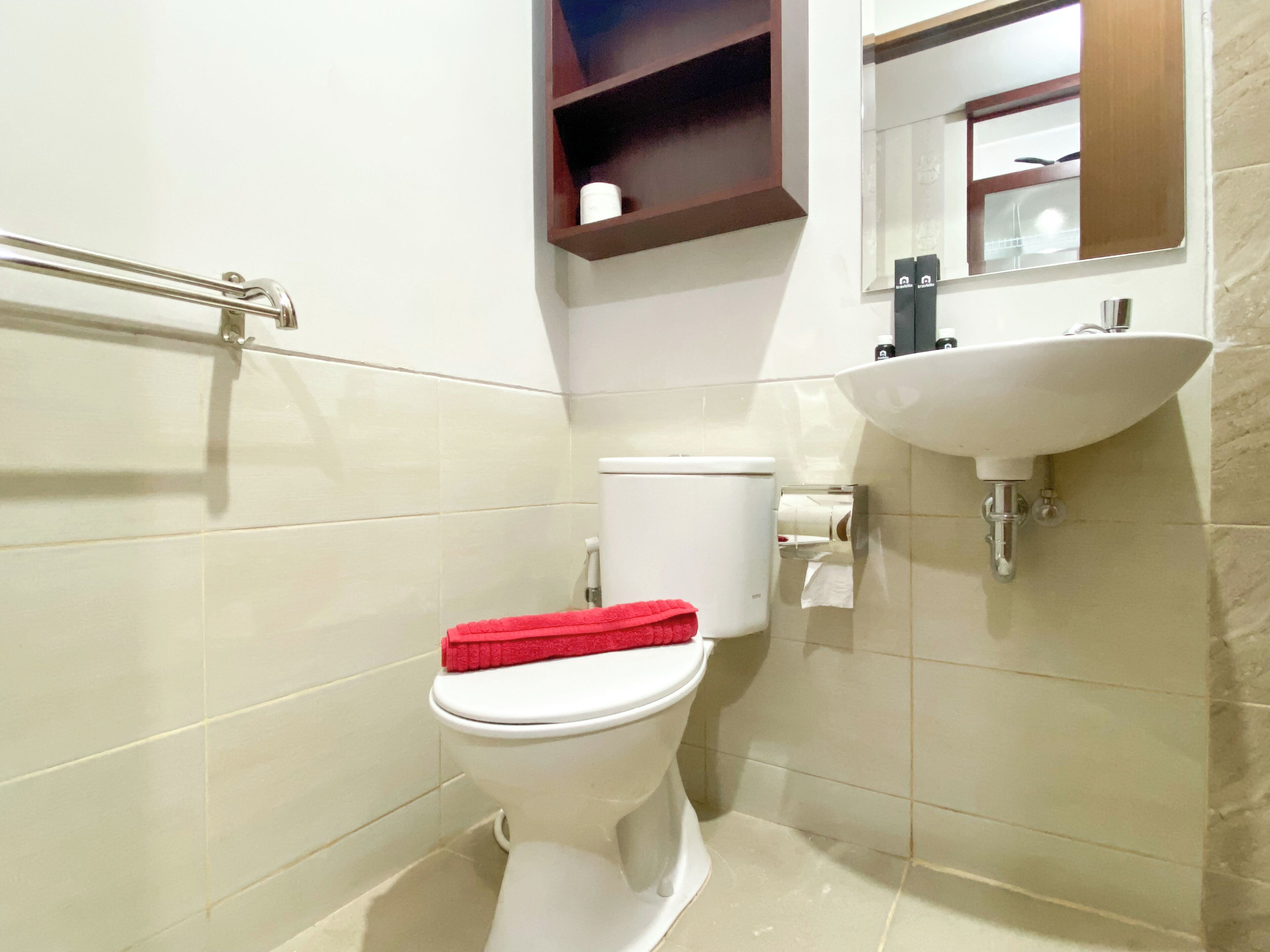A compact bathroom with a toilet, a white sink, and a mirror above the sink.