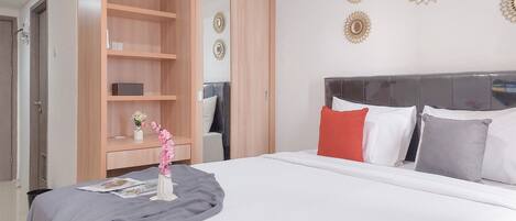 A hotel room with a bed, a wardrobe, and decorative wall mirrors.