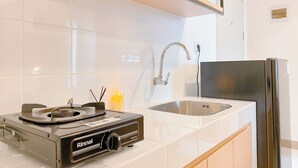 A kitchen with a gas stove, sink, and modern appliances. - Good And Cozy Stay 2Br Tokyo Riverside Pik 2 Apartment (Teluknaga)
