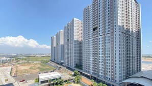 A high-rise residential building with multiple balconies, a parking area, and a clear view of the surrounding landscape. - Spacious 1Br At Tokyo Riverside Pik 2 Apartment (Teluknaga)