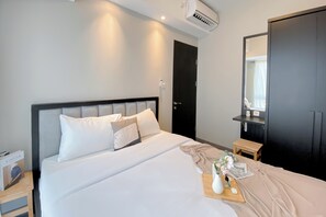 Una habitación de hotel con cama, mesita de noche y espejo.