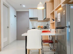 Estudio Deluxe | Cocina privada | Frigorífico grande, horno, placa de cocina y mesa de comedor