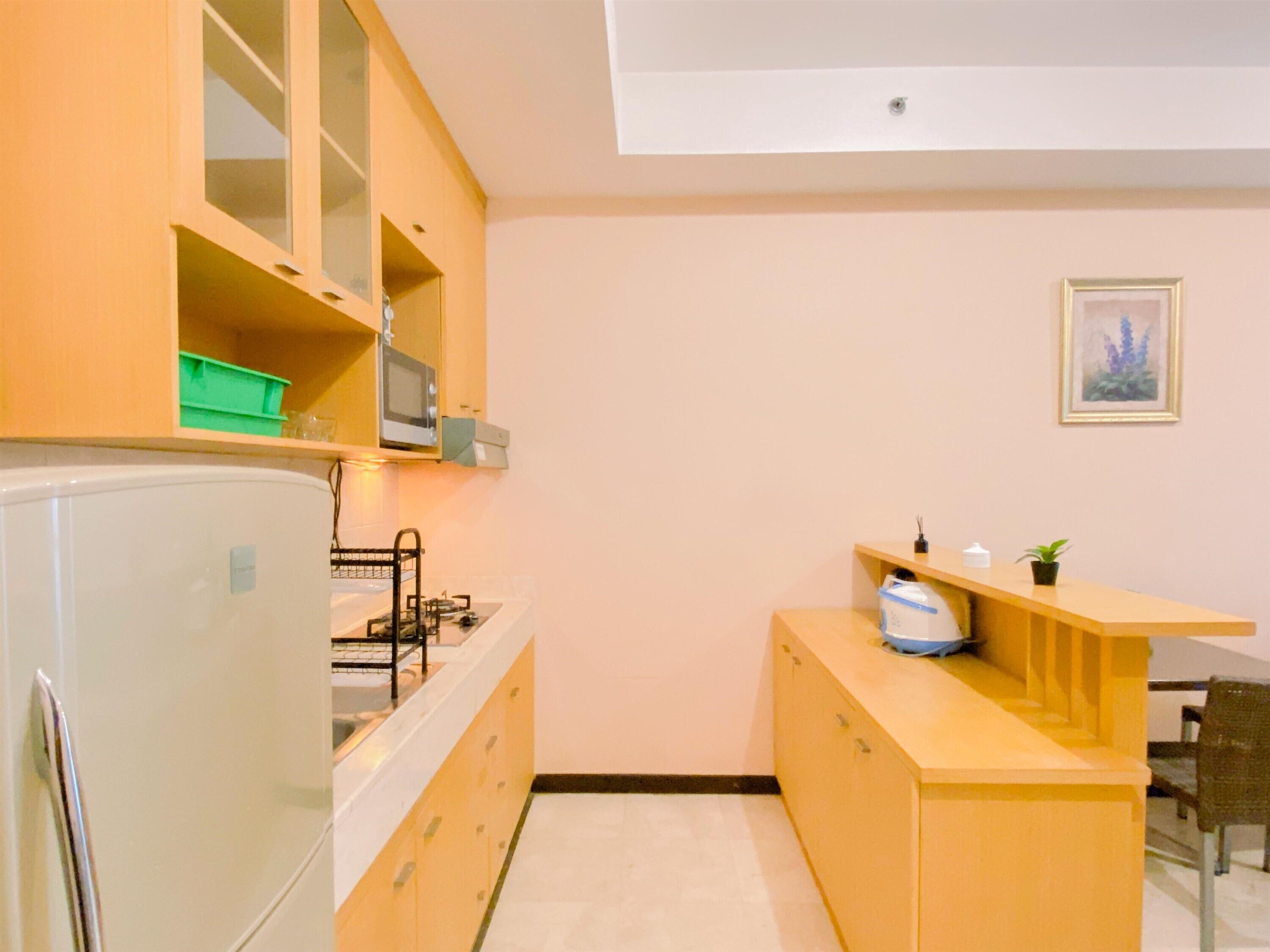A compact kitchen with a refrigerator, stove, microwave, and a small countertop with a sink.