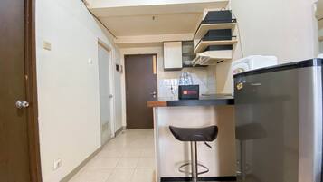 Apartament Deluxe | Cuina privada | Frigorífic, placa de cuina, una taula de menjador i una illa a la cuina