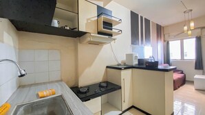 A compact kitchen with a sink, stove, and a small countertop. - Nice 2Br At Apartment Suites @Metro (Bandung)