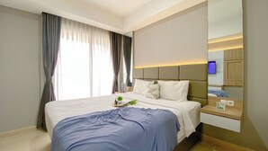 Een moderne hotelkamer met een groot bed, een nachtkastje, een spiegel en uitzicht op het groen.