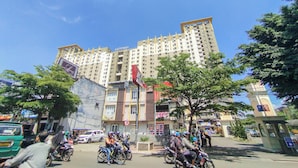 A multi-story building with a prominent "GATEWAY" sign, surrounded by trees and parked motorcycles. - Urban 3Br At Apartment Gateway Ahmad Yani Cicadas (Bandung)