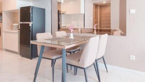 Une cuisine moderne dotée d’un réfrigérateur encastré, d’une table à manger avec des chaises et d’un grand miroir au-dessus de l’évier.