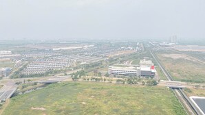 Eine Vogelperspektive auf ein großes Industriegebiet mit mehreren Gebäuden, Straßen und Grünflächen.