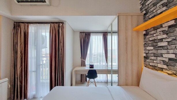 Une chambre d’hôtel équipée d’un lit, d’un bureau, d’une chaise, d’un miroir et d’un appareil de climatisation.