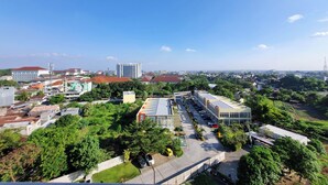 Une vue aérienne d’une ville, avec différents bâtiments, dont un grand immeuble commercial doté d’un parking et un bâtiment plus petit surmonté d’un toit végétalisé.