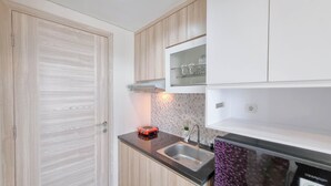 Une cuisine avec des meubles en bois, un évier en acier inoxydable et un réfrigérateur noir.