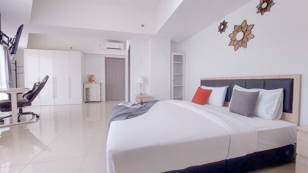 A modern hotel room with a large bed, a desk, and a chair. - Comfortable And Homey 1Br Tamansari Bintaro Mansion Apartment (South Tangerang)