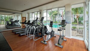 A gym with treadmills, elliptical machines, and a stationary bike. - Comfort Studio Room At Vida View Apartment (Makassar)