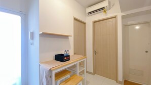 A room with a desk, a shelf, and two doors. - Cozy Living 2Br Apartment At Tokyo Riverside Pik 2 (Teluknaga)