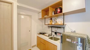 Apartament Deluxe | Cuina privada | Frigorífic, placa de cuina i una taula de menjador 