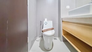 Ένα σύγχρονο μπάνιο με λευκή τουαλέτα, ντους και ξύλινο νιπτήρα.