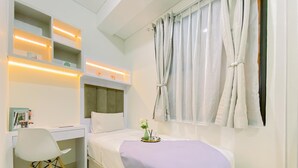 A bedroom with a bed, a desk, and a chair. - Good Place And Homey 2Br At Transpark Cibubur Apartment Near Mall (Depok)