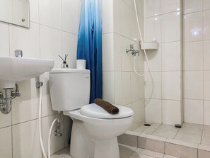Un bagno con il water, lavandino e doccia.