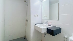 Une salle de bain avec une douche, un lavabo et des toilettes.
