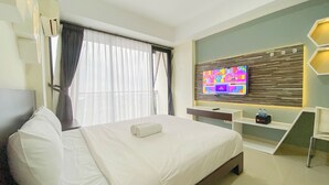 Une chambre d’hôtel équipée d’un lit, d’un téléviseur fixé au mur, d’un bureau et d’une chaise.