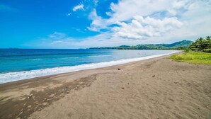 A beach with a clear sky and calm sea. - Luxury Villa | Infinity Pool & Ocean Views (Playa Potrero)