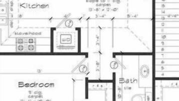 A floor plan with a kitchen, living room, bedroom, and bathroom. The kitchen has a stove hood, the living room has a slope to the ceiling, and the bedroom has a window seal.