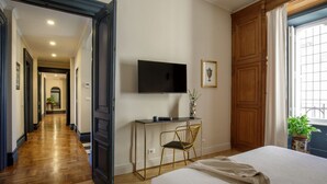 Une chambre d’hôtel avec un lit, un bureau et une chaise, une télévision et une fenêtre donnant sur un beau paysage.