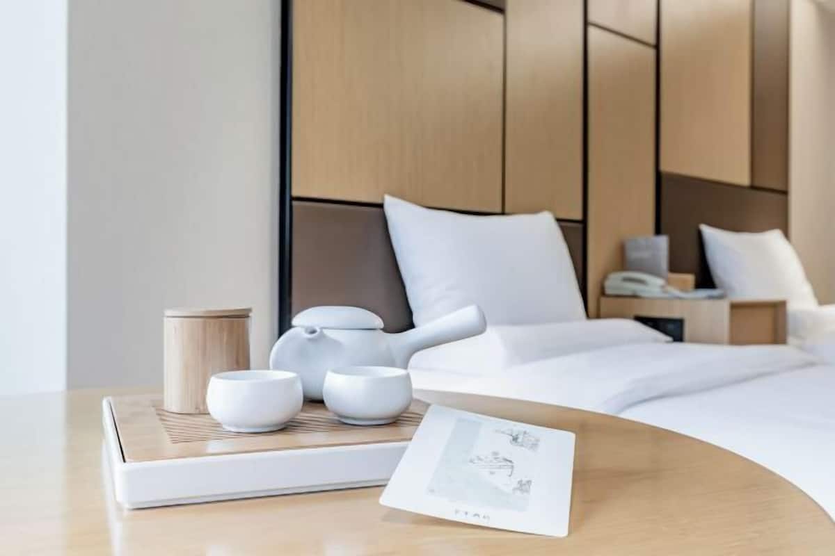 A neatly arranged hotel room with a bed, bedside table, and a nightstand.
