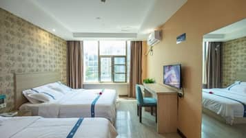 Une chambre d’hôtel avec deux lits, un bureau, une télévision et une fenêtre donnant sur des immeubles.