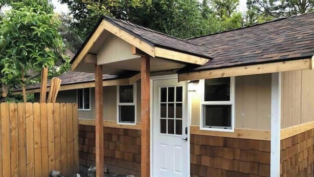 Un petit bâtiment d’un seul étage, doté d’un toit en pente, d’une porte d’entrée et de deux fenêtres.